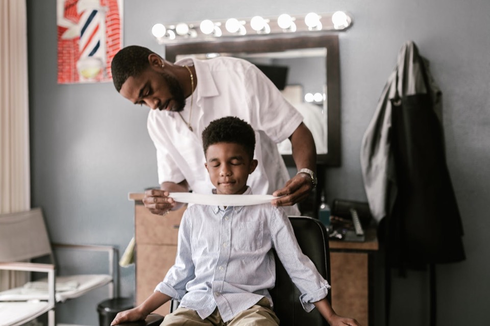Young boy having a neat haircut in a barbershop